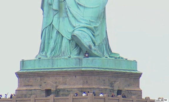 محتجة تتسلق قاعدة تمثال الحرية -فيديو