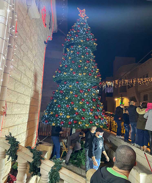 مسلمون يعيدون بناء شجرتي ميلاد أحرقهما مجهولون في سخنين- صور