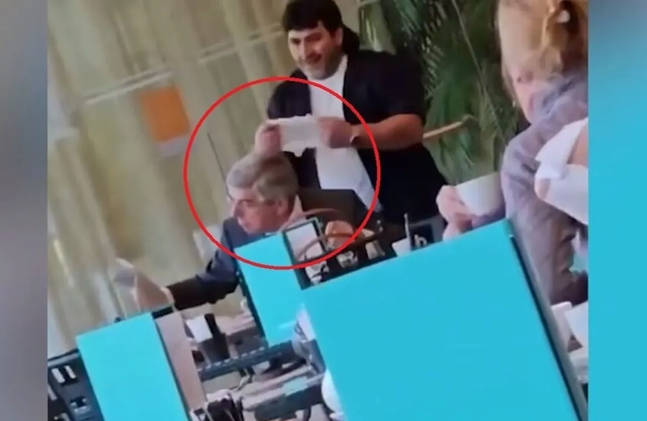 رجل يضع حفاضة طفل على رأس رئيس اللجنة الأولمبية الدولية  فيديو