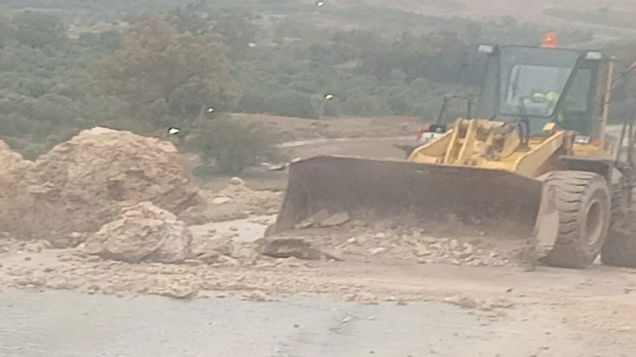 آلية تابعة لبلدية الكرك تعمل على فتح أحد الطرق المغلقة بسبب الانهيارات