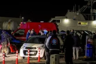 مسعفون وجنود في ميناء جزيرة خيوس عقب تصادم بين سفينة تابعة لخفر السواحل اليوناني وقارب يحمل مهاجرين