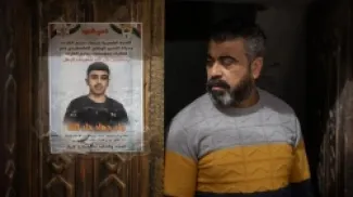 يقف والد جاد بجوار ملصق تذكاري على باب منزلهم الأمامي. ويقول: 