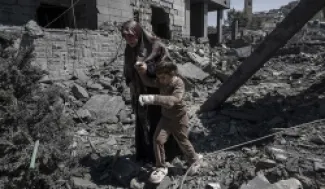 امرأة لبنانية مع طفلتها، ويحيطهما الدمار