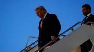 ترمب يتبعه ابنه يترجلان من طائرة الرئاسة في مطار بالم بيتش  - ارشيف