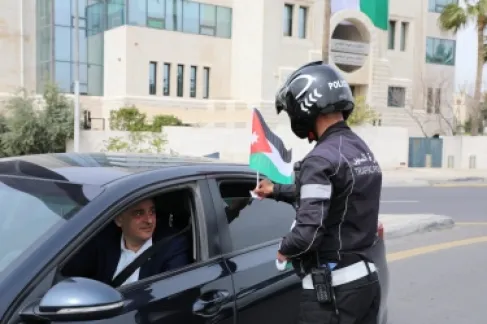 الأمن العام يباشر بلصق وتوزيع العلم الأردني على مركبات المواطنين احتفاءً بيوم العلم
