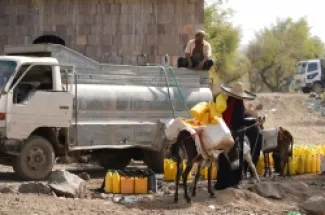 يمنيون يتزوّدون بالماء من شاحنة توزيع في مخيم مؤقت للنازحين قرب تعز