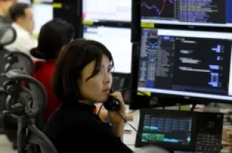متداولة أمام شاشة في غرفة تداول العملات الأجنبية بمقر بنك هانا في سيول، كوريا الجنوبية