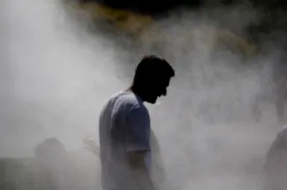 رجل يسير تحت نظام رذاذ تم تركيبه خلال موجة حر في ستراسبورغ شرقي فرنسا