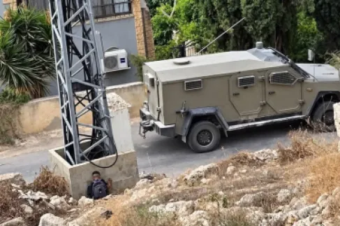 طفل فلسطيني يتوارى خلف عمود بالضفة الغربية خوفا من جنود الاحتلال