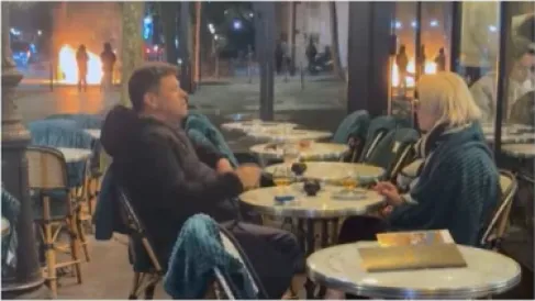 كأن شيئاً لم يحدث.. زوجان يحتسيان مشروبهما وسط نيران باريس