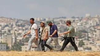 صورة أرشيفية لمستوطنين إسرائيليين يحملون أسلحة نارية في أرض فلسطينية ببلدة بيت ساحور في الضفة الغربية المحتلة