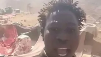 أحد المعدّنين يشير إلى موقع غارة جوية في منطقة شمال الوادي بولاية البحر الأحمر السودانية، قرب الحدود المصرية.