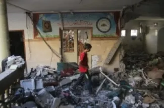 فلسطينيون يتفقدون الدمار عقب الهجوم الإسرائيلي على مبنى مدرسة 